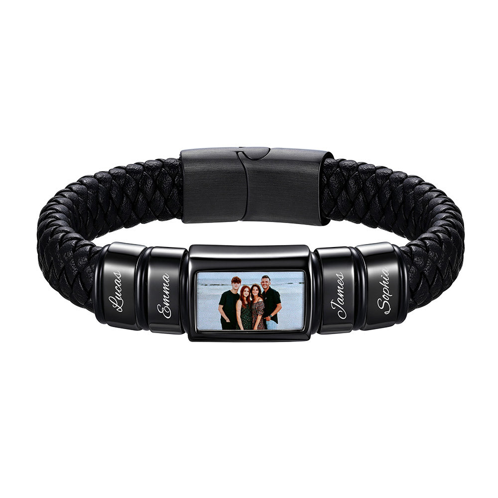 A personalized black braided leather and metal bracelet featuring a central rectangular photo frame and four engraved name beads, shown on a plain white background.