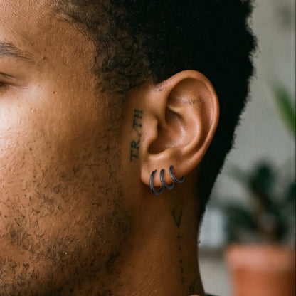 Close-up of a person's ear with tattoos and a blurred background