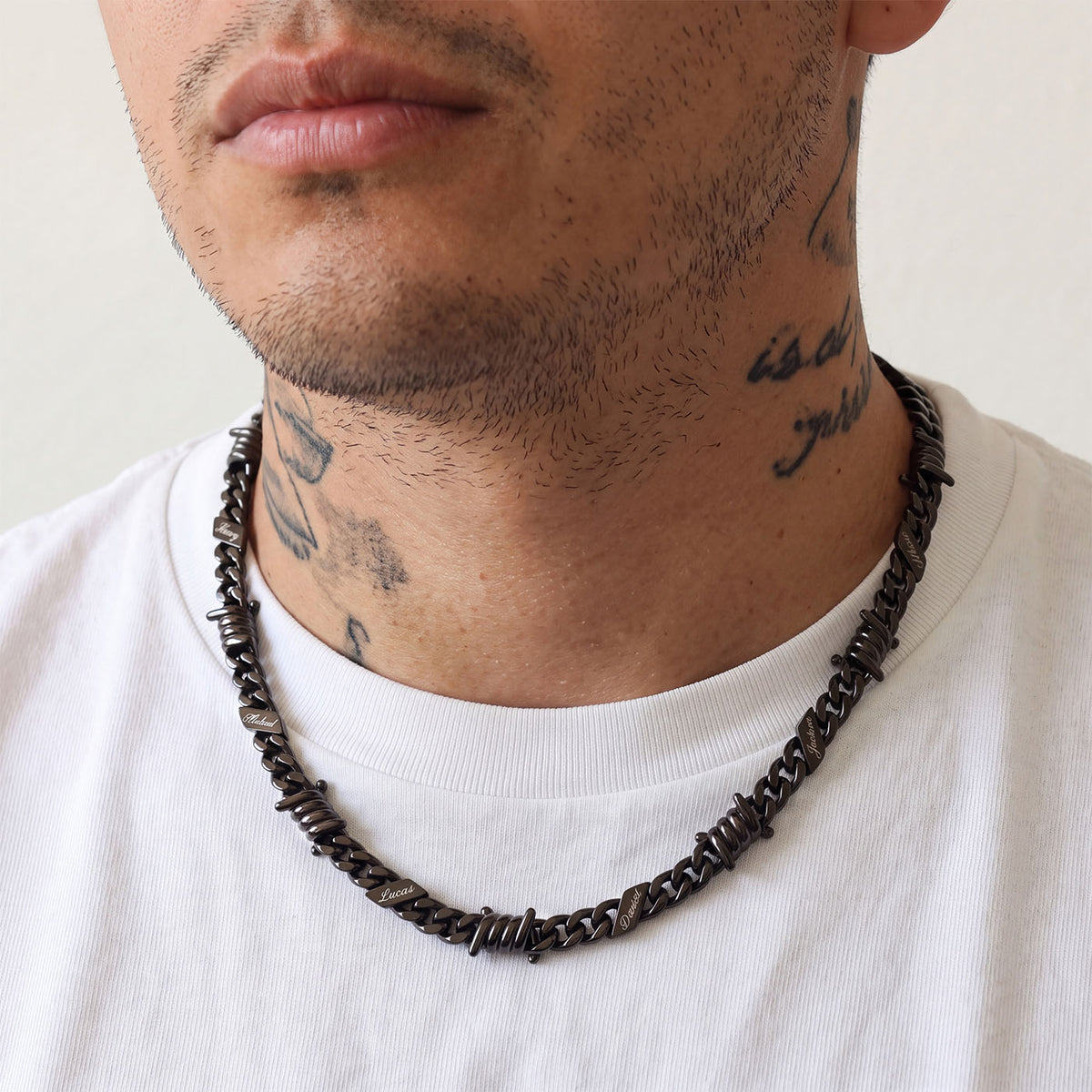 A Man Wearing Black Plated Personalized Multi-Name Barbed Wire Cuban Link Necklace
