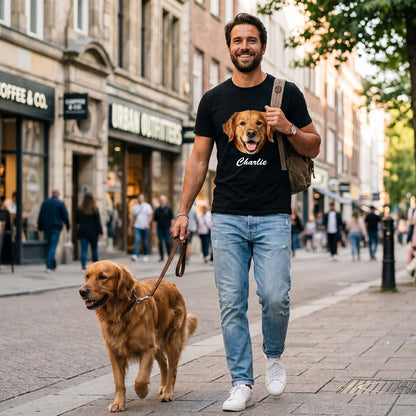 A Man walking a dog on a city street wearing a t-shirt with a dog's face and name.