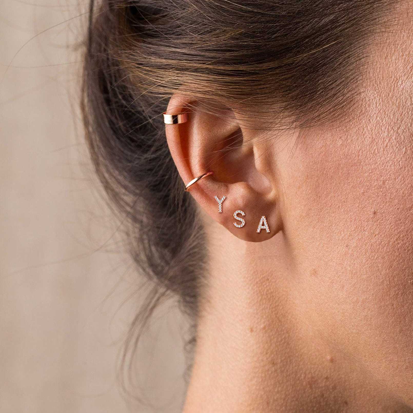 A Woman Wearing 925 Sterling Silver CZ Initial Stud Earrings