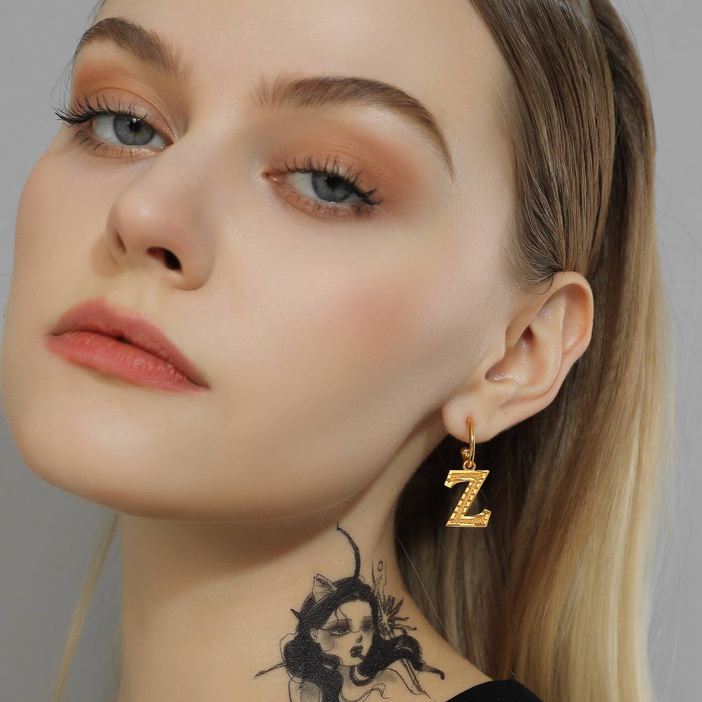 A Woman Wearing Alphabet Initial Hoop Earrings 