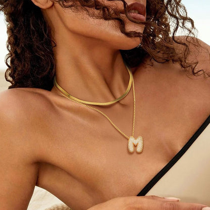 A Woman Wearing CZ Gold Bubble Letter Necklace