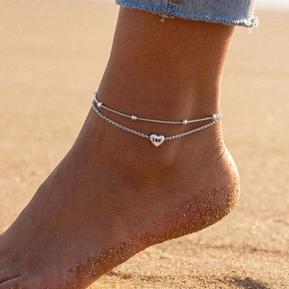 A Woman Wearing Custom Engraved Layered Heart Anklets in 925 Sterling Silver
