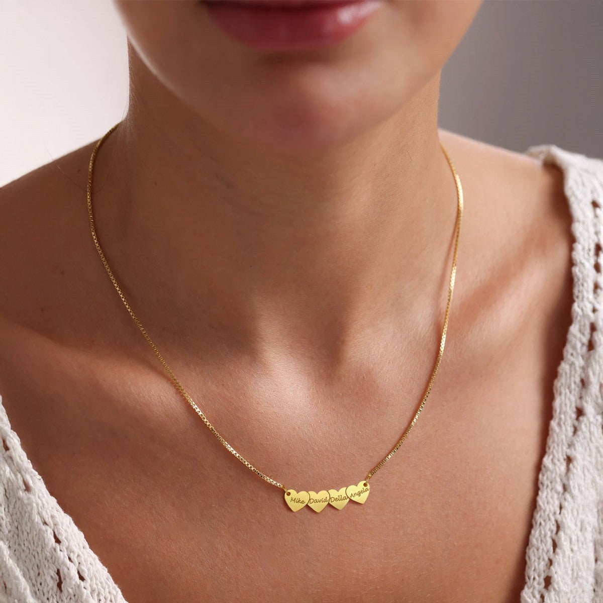 A Woman Wearing Engraved 4 Hearts Name Necklace