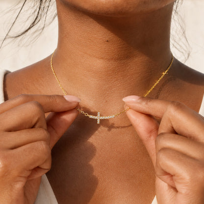 A Woman Wearing Gold Dainty Cubic Zirconia Sideways Cross Necklace for Women 