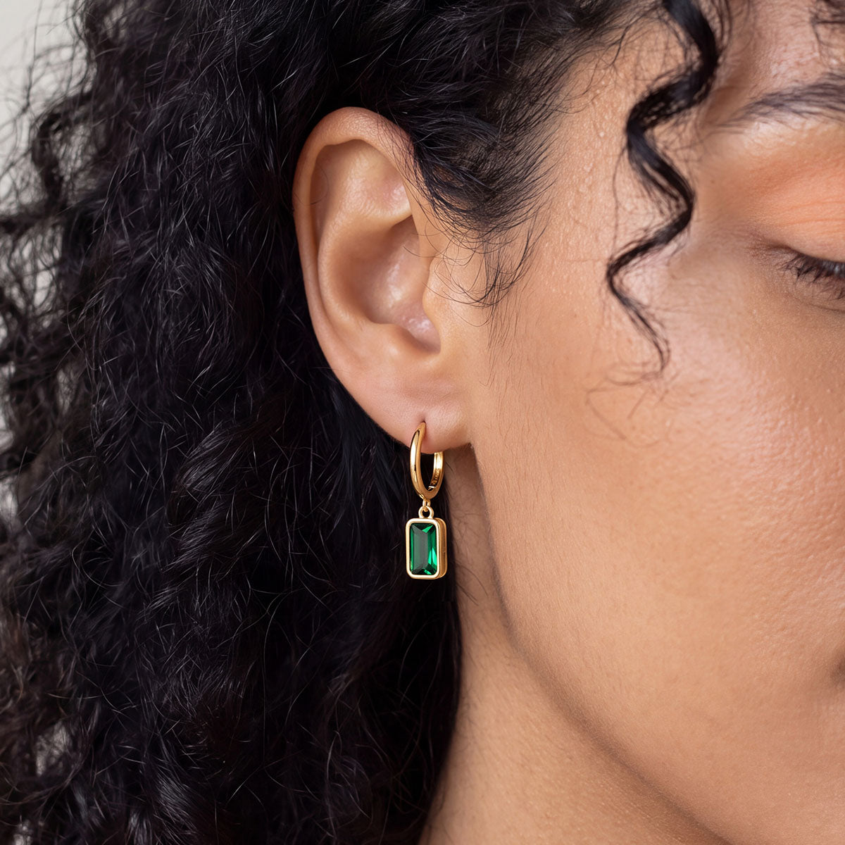 A Woman Wearing Rectangular Baguette‑Cut Birthstone Huggie Dangle Earrings