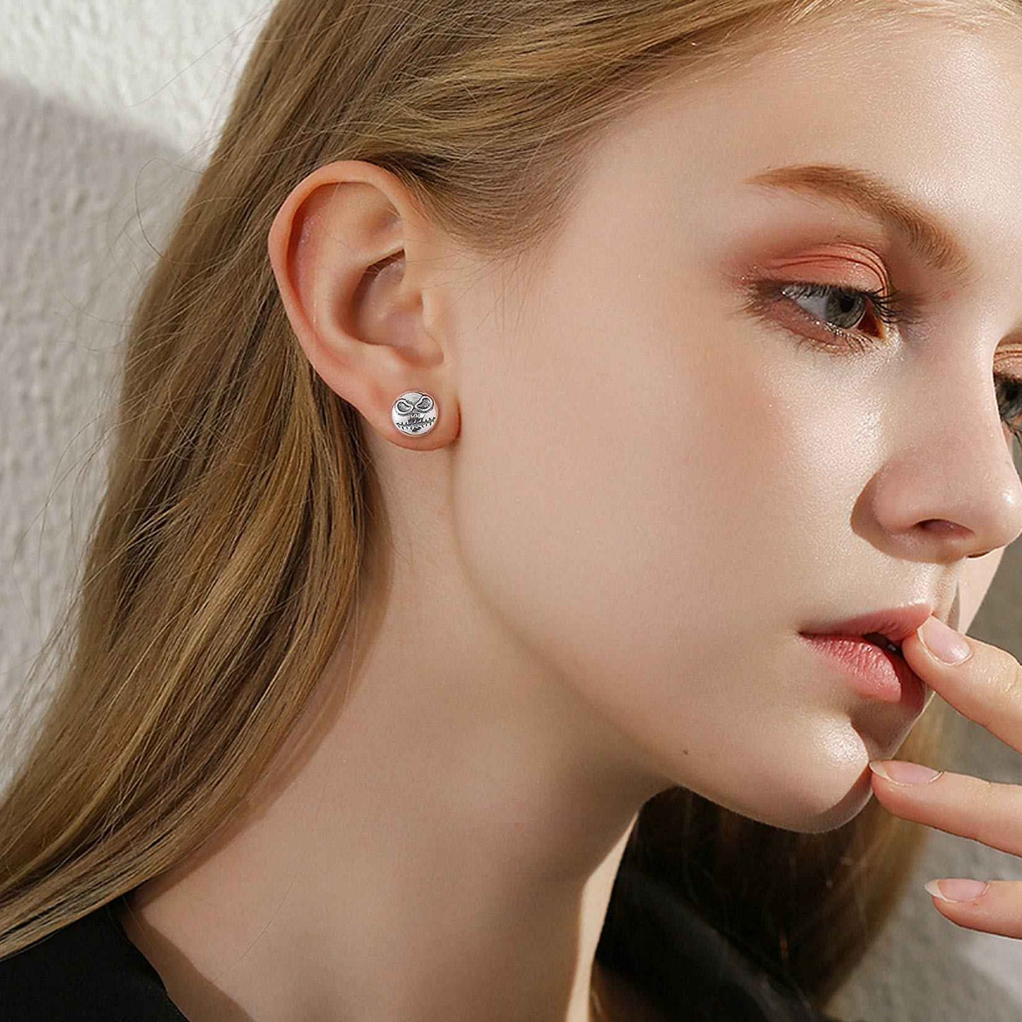 A Woman Wearing Silver Skull of Jack Stud Earrings