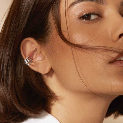 A Woman Wearing Skull Hand Ear Cuff Earrings