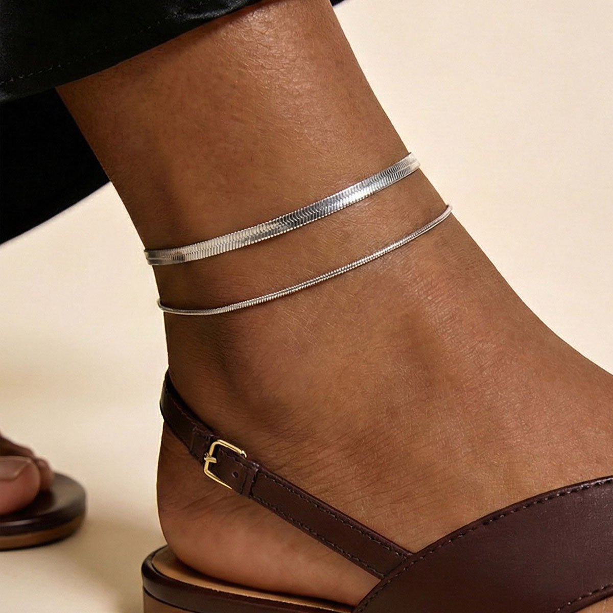 A Woman Wearing Steel Flat Snake Chain Layered Anklets