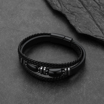 A black Obsidian multilayer leather bracelet with polished metallic silver-toned accent beads, displayed on a dark textured slate surface.