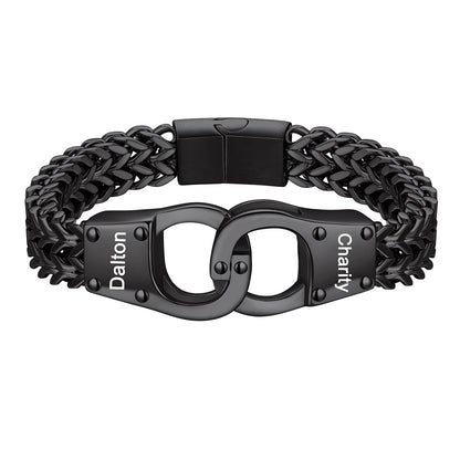 A black metal chain bracelet with a central clasp designed like handcuffs, featuring the words 'Dalton' and 'Charity' engraved on the links, shown on a plain white background.