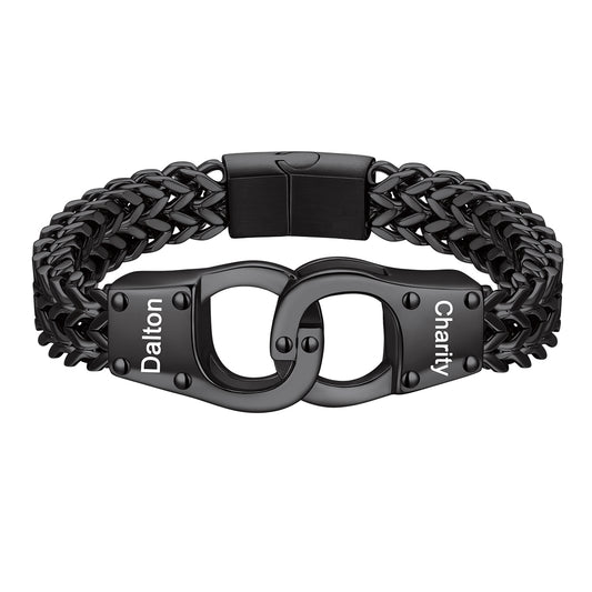 A black metal chain bracelet with a central clasp designed like handcuffs, featuring the words 'Dalton' and 'Charity' engraved on the links, shown on a plain white background.