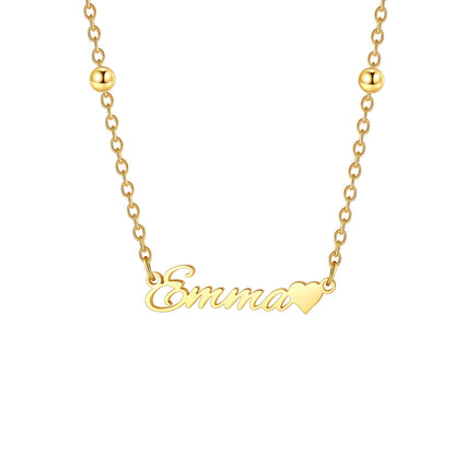 A close-up of a woman wearing a delicate silver necklace with a small letter 'G' pendant, styled with small silver beads on the chain.