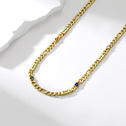A gold-toned Cuban link chain necklace with small rectangular nameplates engraved with zodiac signs and tiny colored gemstone accents, displayed on a clean white surface.