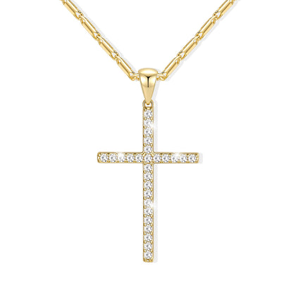 A gold cross necklace with clear pavé stones, suspended from a gold paperclip chain against a solid white background.