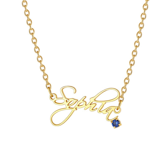 A gold nameplate necklace spelling 'Sophia' in cursive script, featuring a small blue gemstone accent at the bottom right of the lettering, shown on a plain white background.