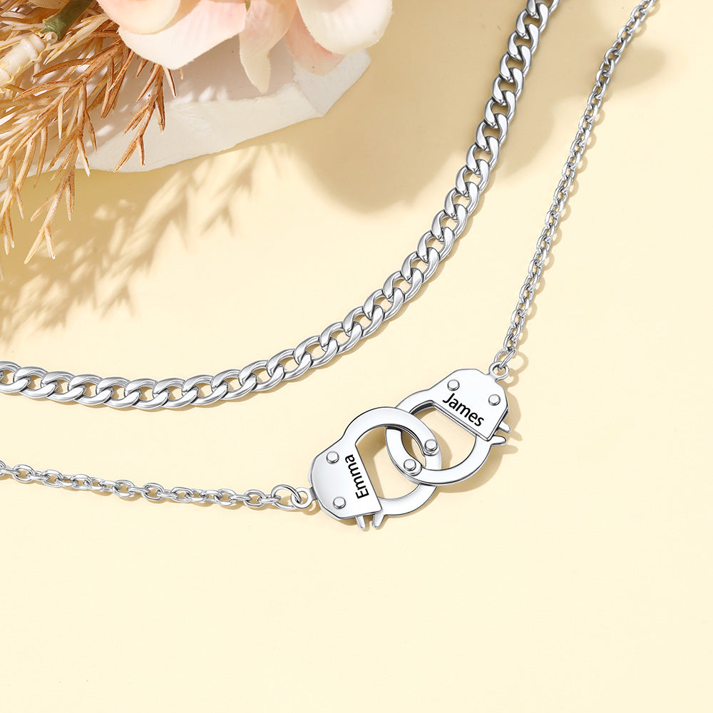 A silver-toned double-layer hankcuff anklet on a light yellow background