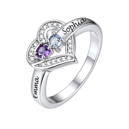 A silver birthstone ring with two gemstones, one purple and one light blue, set with small clear stones. The top of the heart is engraved with the name 'Sophia' and the band is engraved with 'Emma'.