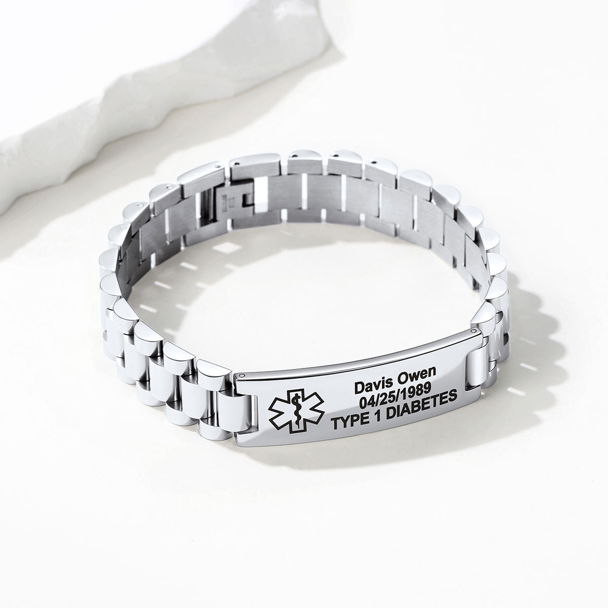 A silver stainless steel link medical alert bracelet with a personalized ID plate engraved with a Star of Life symbol, the name 'Davis Owen', date '04/25/1989', and 'TYPE 1 DIABETES'.