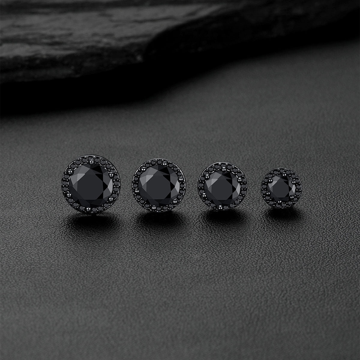 Black CZ Halo stud earrings arranged on a dark textured surface