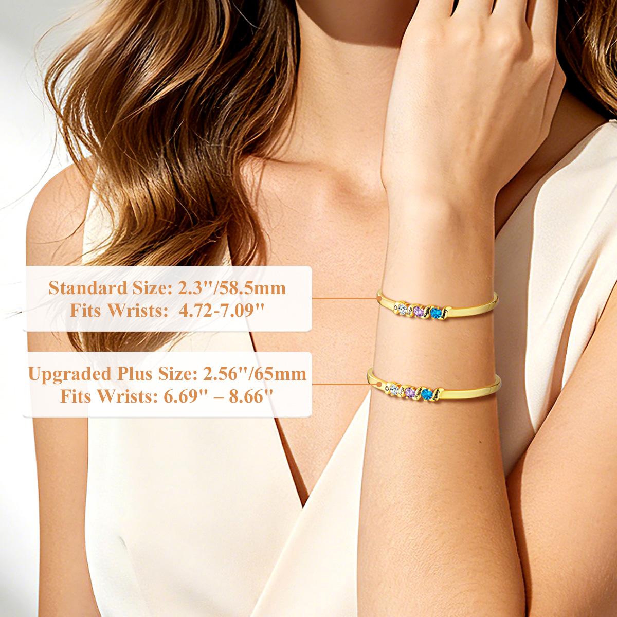 Gold birthstone bracelets on a person's wrist with size information displayed.