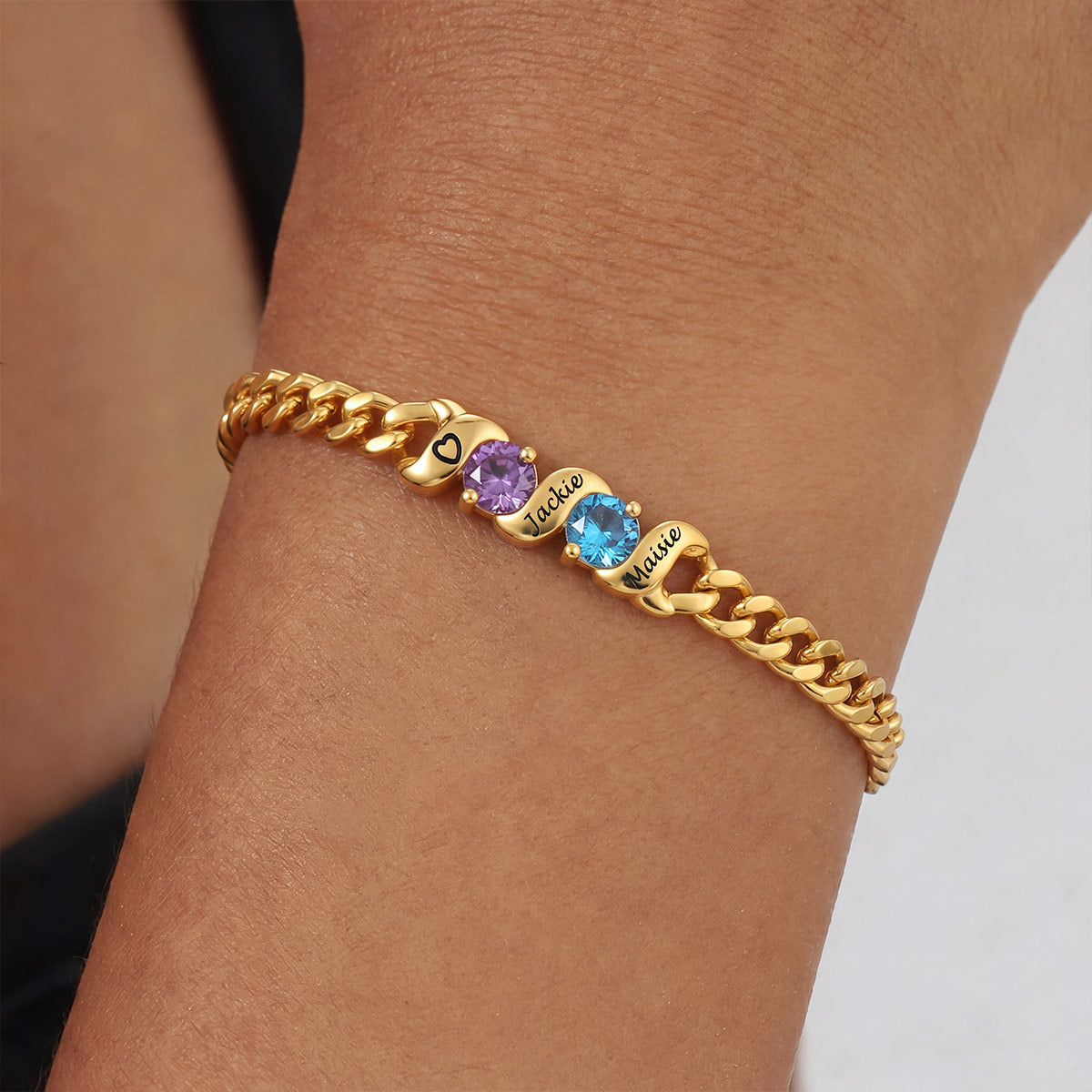 Gold chain bracelet with colored stones on a wrist