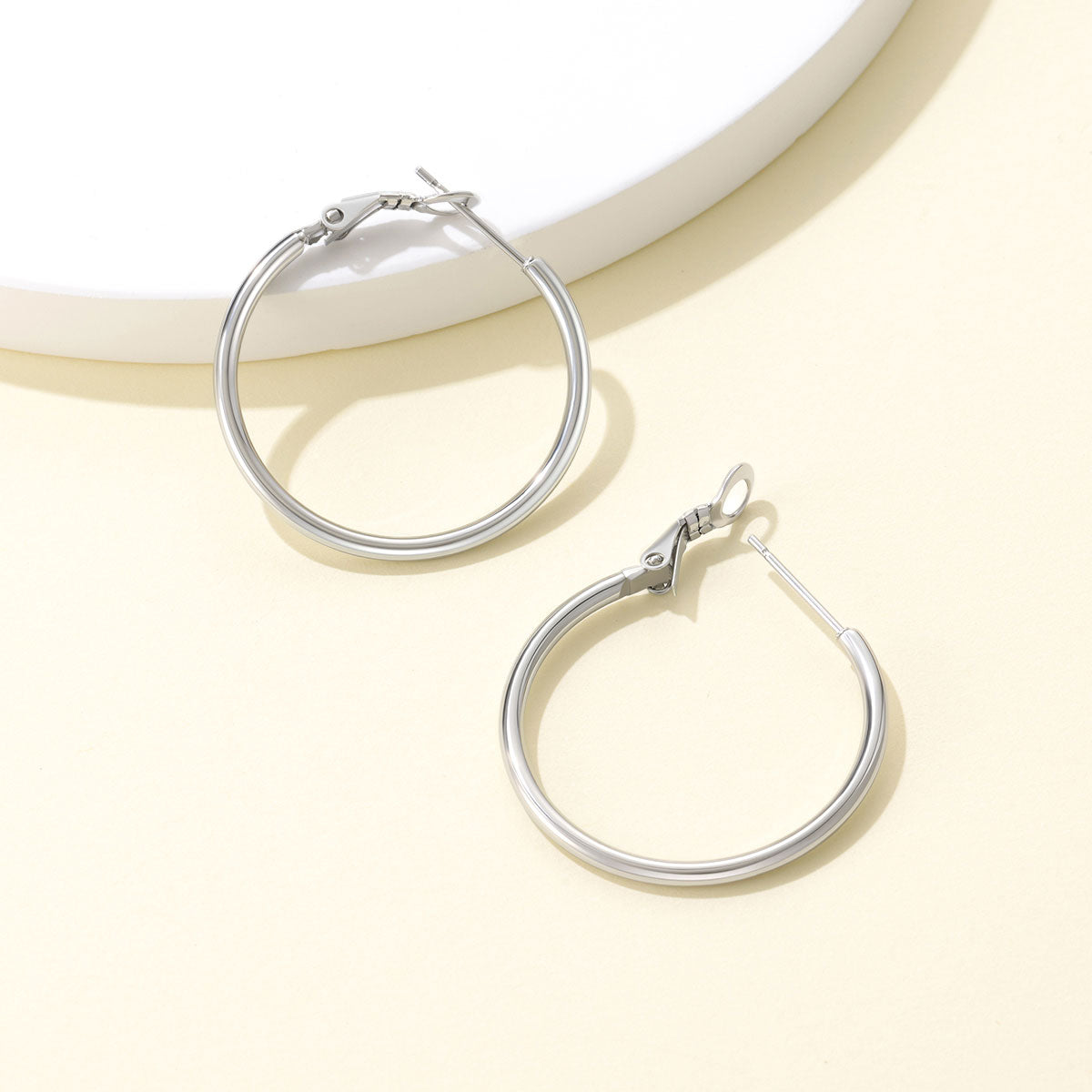 Classic Statement Hoop Earrings for Women on a ligth yellow background