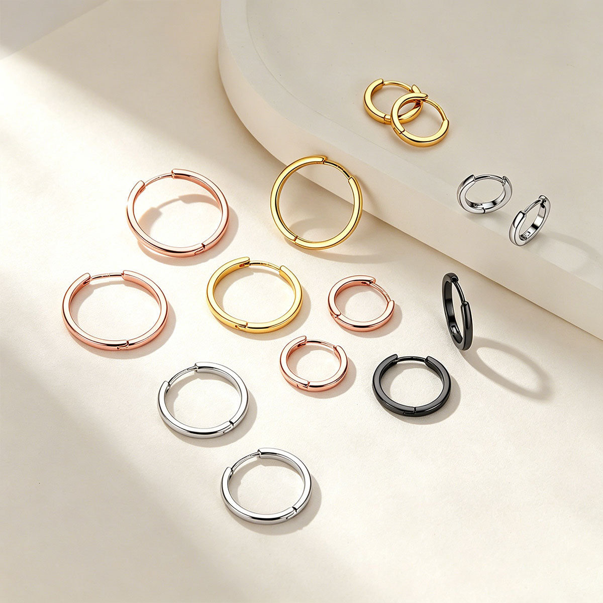 Collection of hoop earrings in various colors on a light background