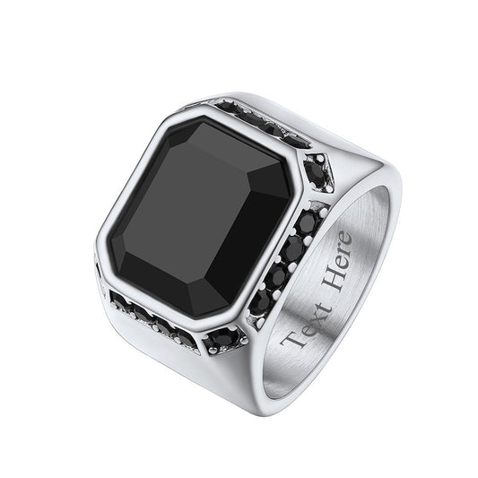 A men's band ring with a large black onyx stone in the center, surrounded by smaller black stones