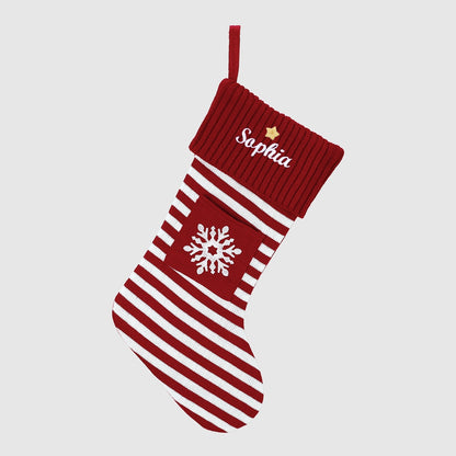 Red Personalized Embroidered Name Striped Christmas Stocking with Holiday Decor handing on a white background