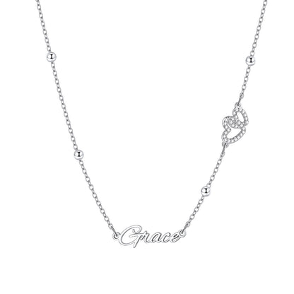 Custom engraved nameplate necklace with heart detail on a white background