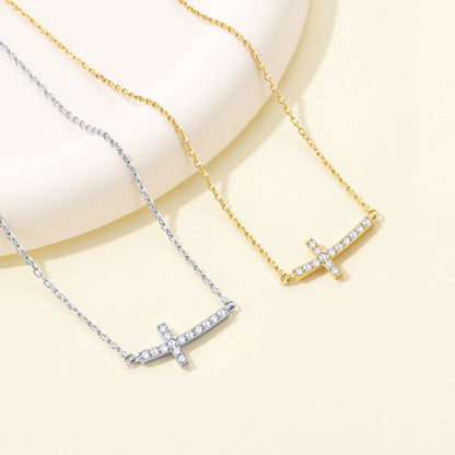 Dainty Cubic Zirconia Sideways Cross Necklace for Women in different color on a light yellow background
