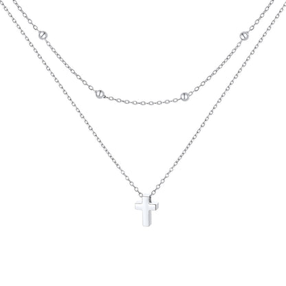 Silver layered cross necklace on a white background
