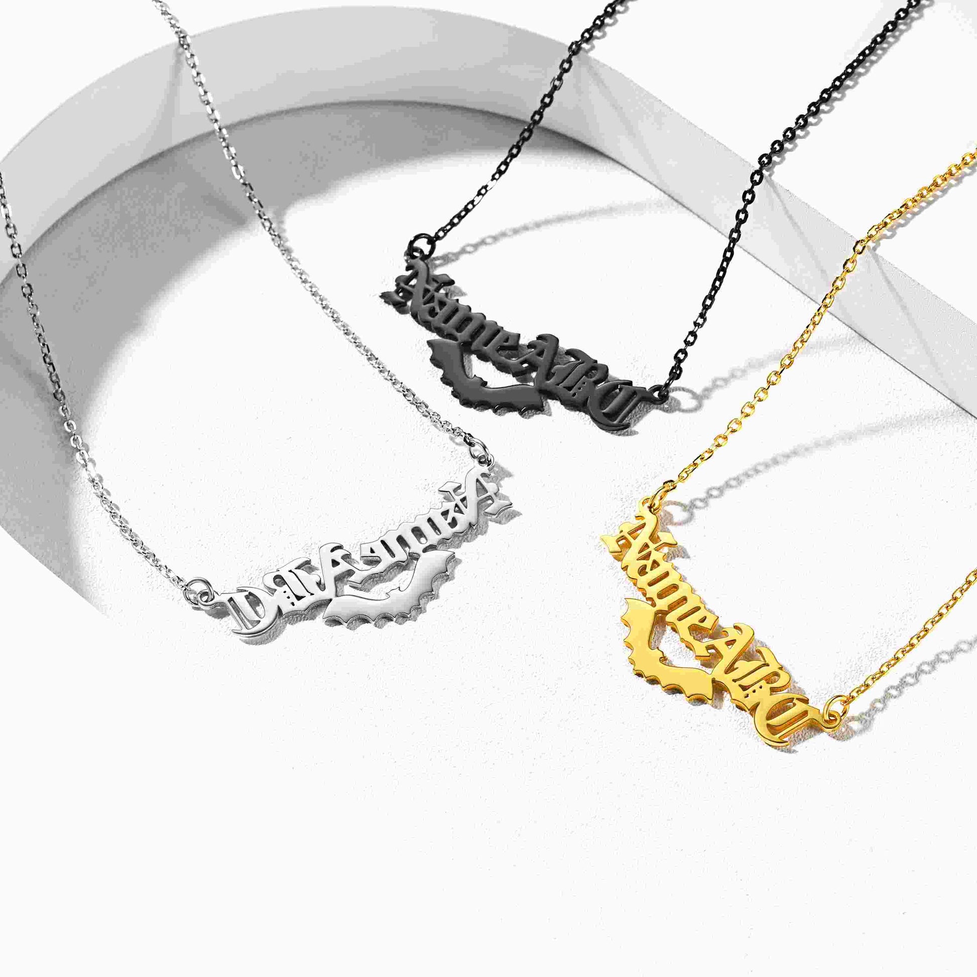 Four custom name necklaces with different nameplate designs on a white background