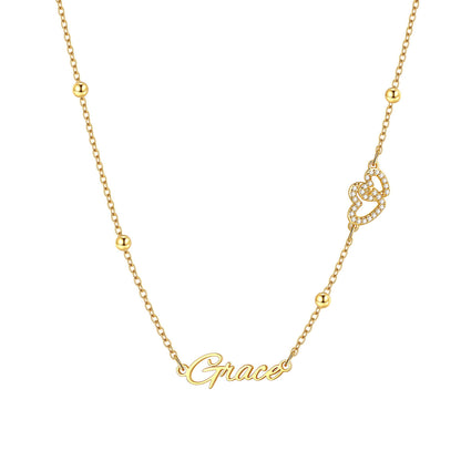 Gold Personalized engraved nameplate necklace with heart detail on a white background