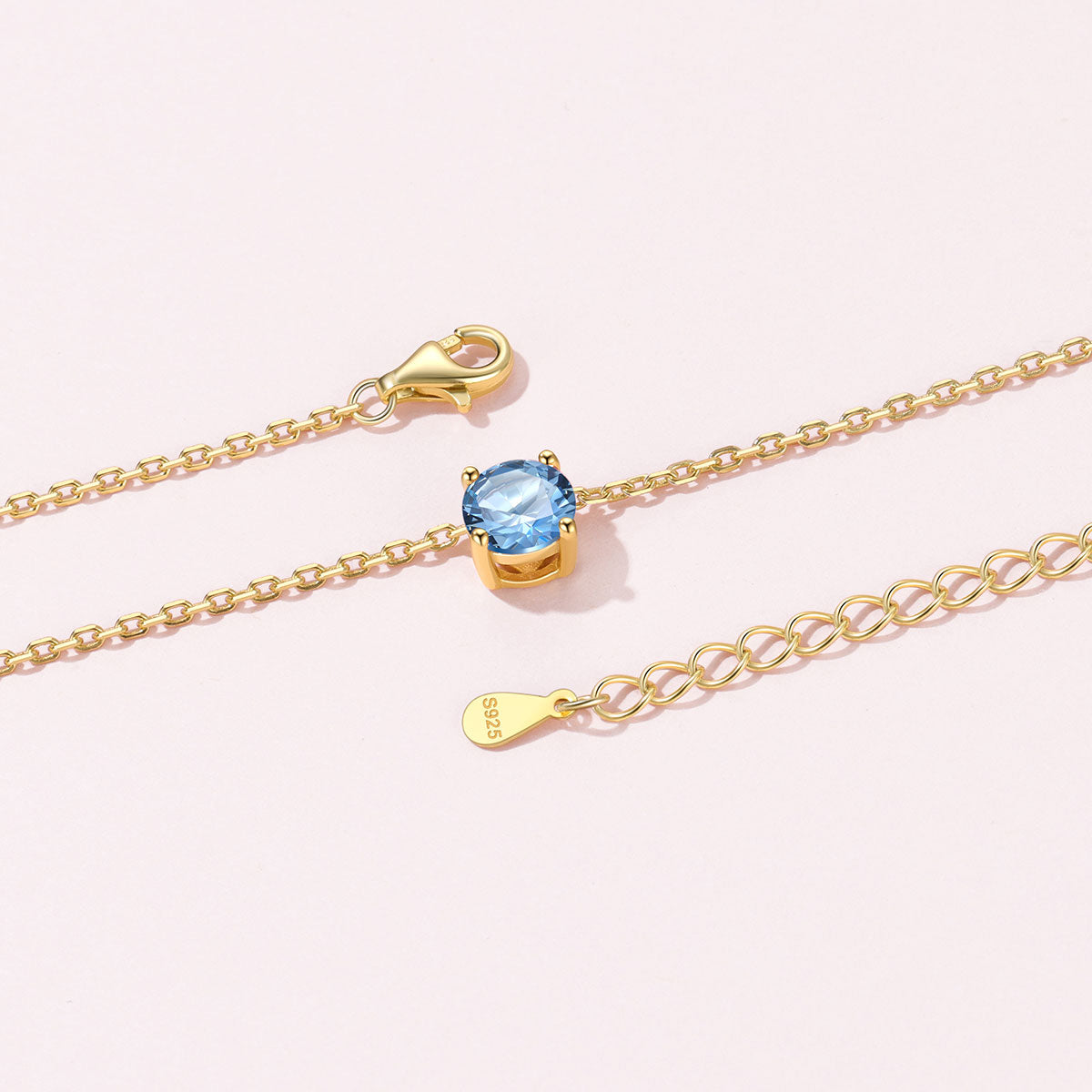 Gold Plated Solitaire Birthstone March Necklace on a pink background