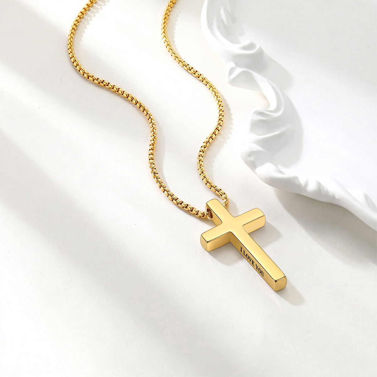 Gold cross necklace on a white background