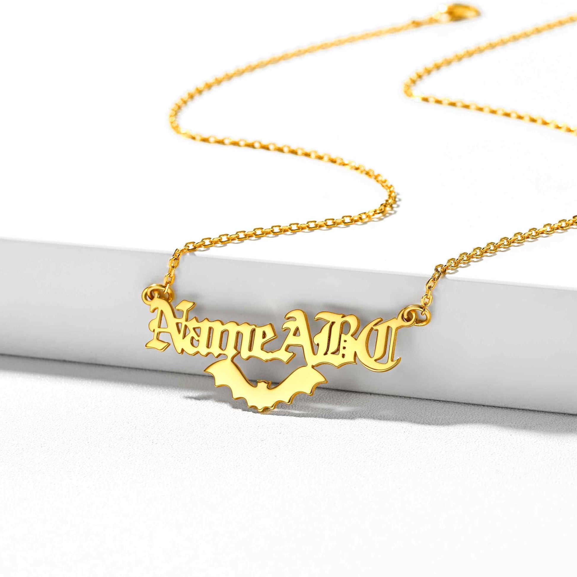 Gold custom bat name necklace with 'Name ABO' pendant on a white background