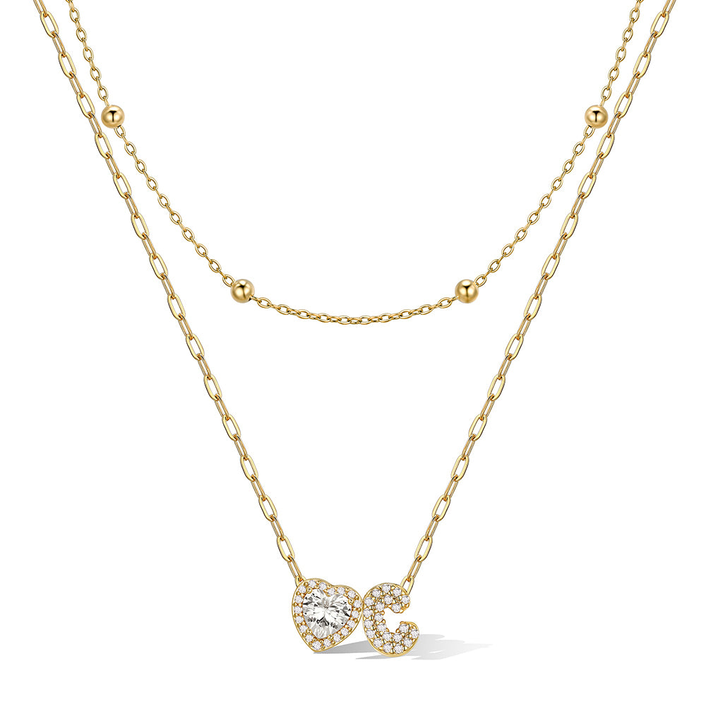 Gold cz bubble initial C necklace with a heart-shaped pendant on a white background