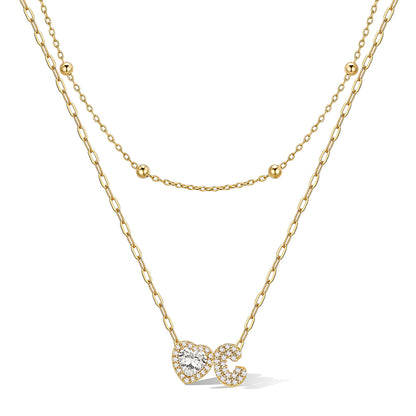 Gold cz bubble initial C necklace with a heart-shaped pendant on a white background