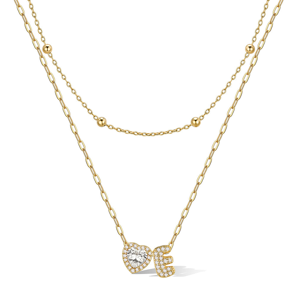 Gold cz bubble initial E necklace with a heart-shaped pendant on a white background
