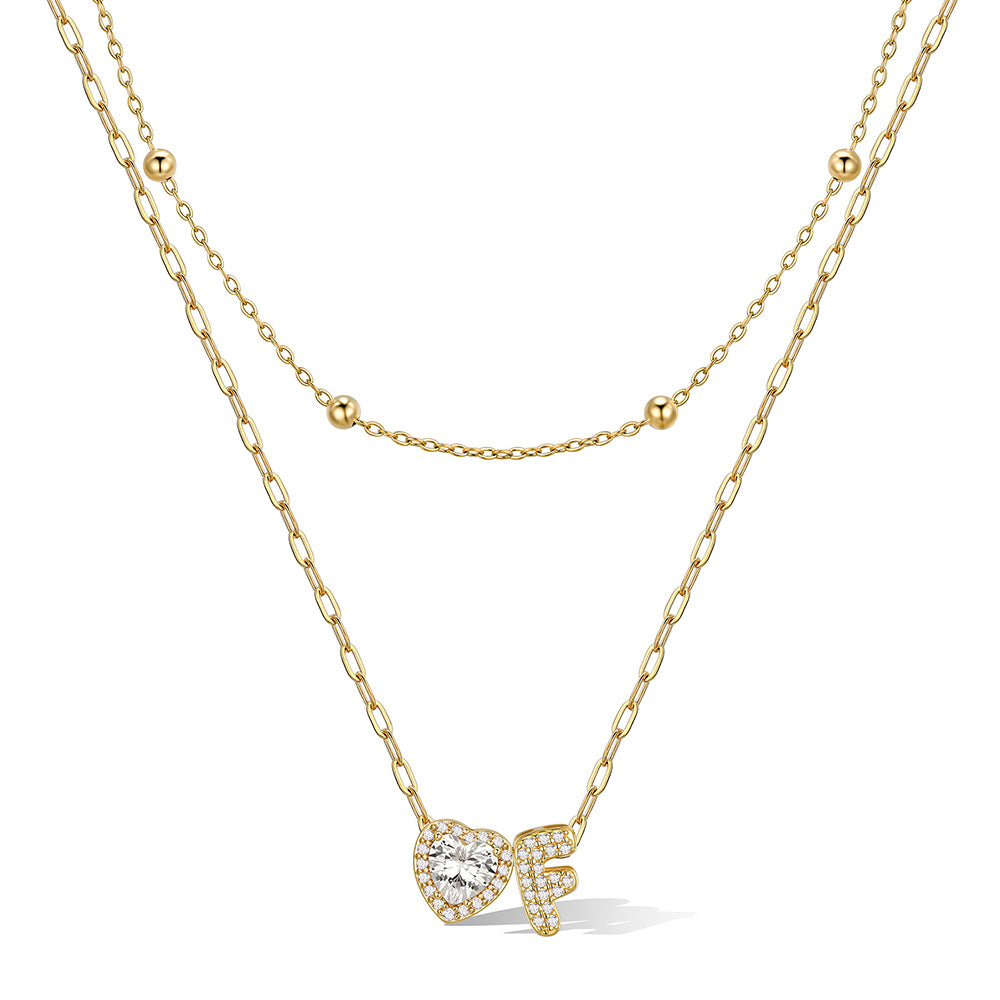Gold cz bubble initial F necklace with a heart-shaped pendant on a white background
