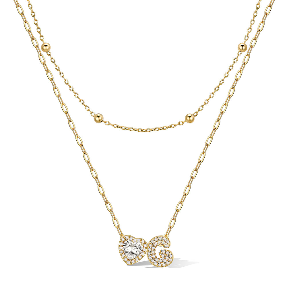 Gold cz bubble initial G necklace with a heart-shaped pendant on a white background