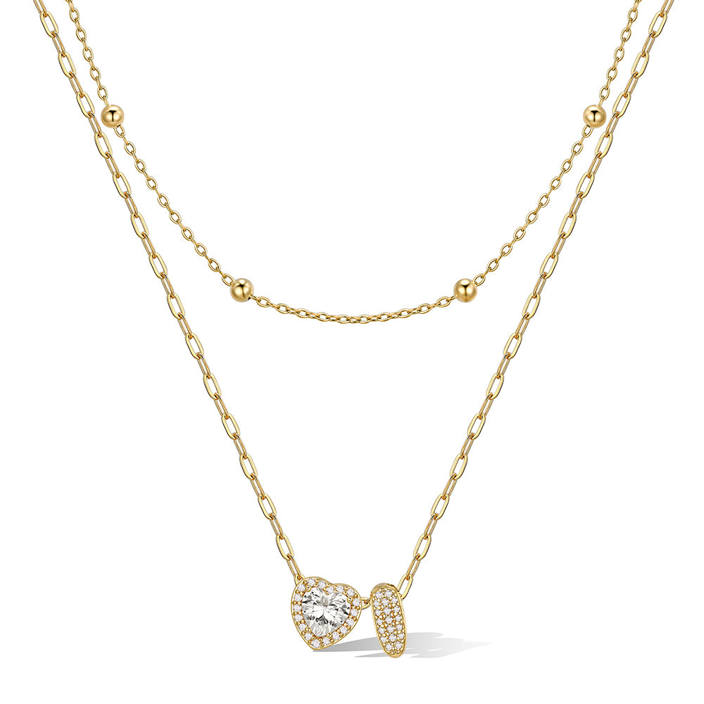 Gold cz bubble initial I necklace with a heart-shaped pendant on a white background