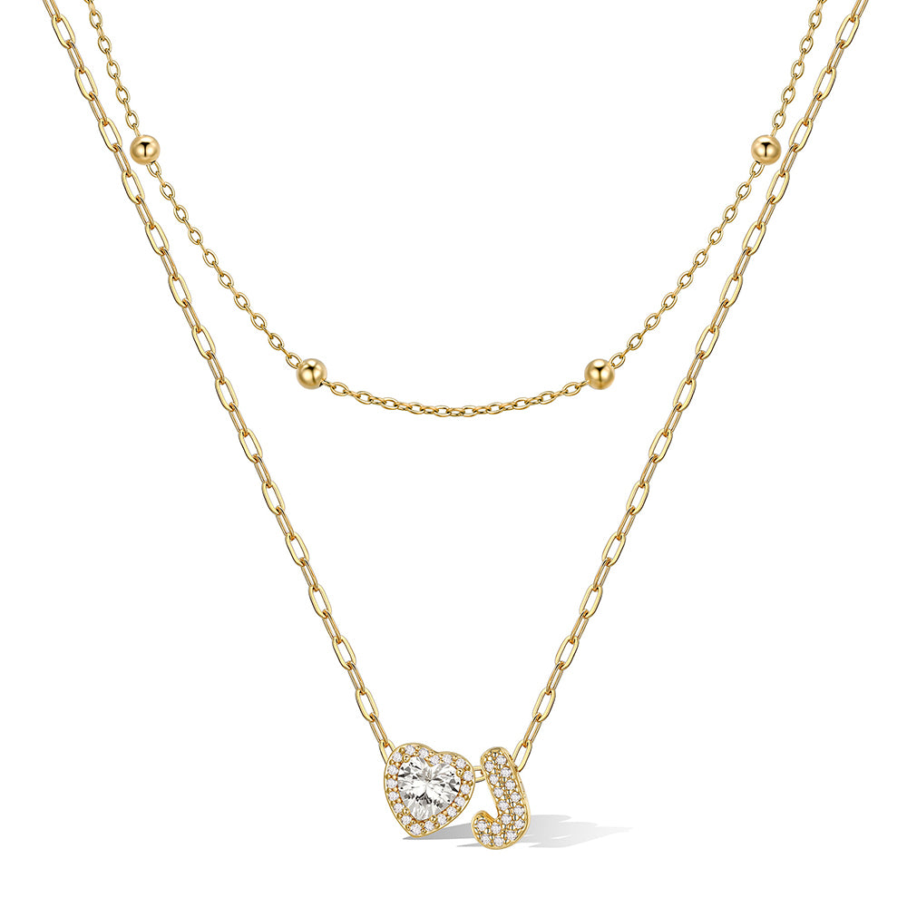 Gold cz bubble initial J necklace with a heart-shaped pendant on a white background