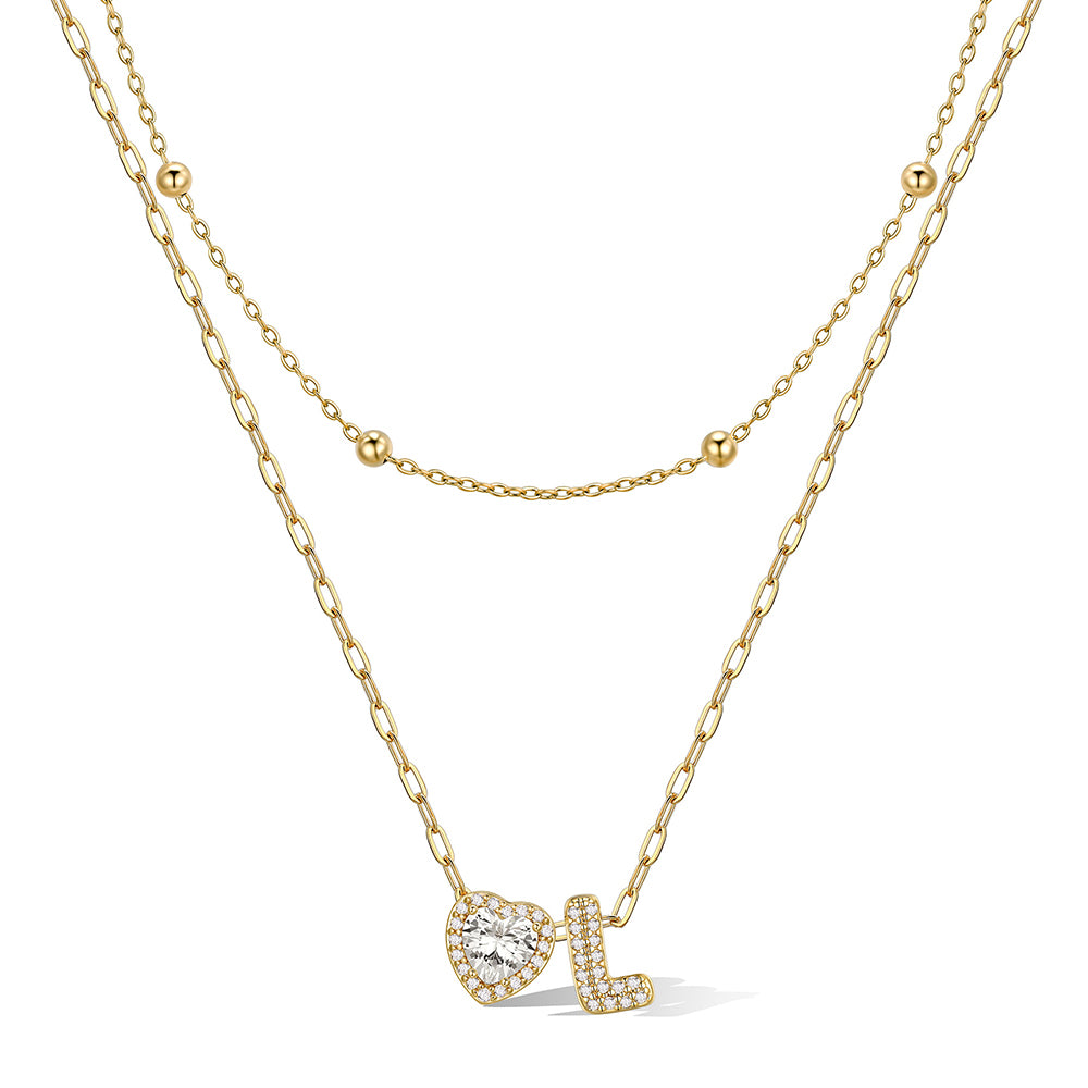 Gold cz bubble initial L necklace with a heart-shaped pendant on a white background