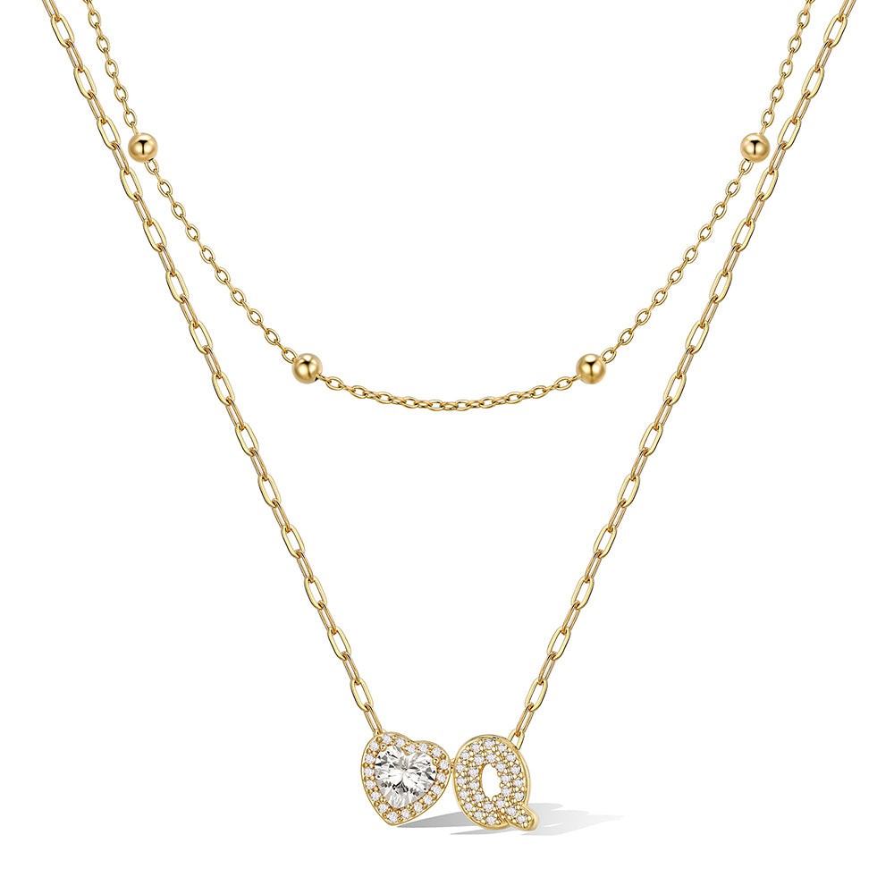 Gold cz bubble initial Q necklace with a heart-shaped pendant on a white background