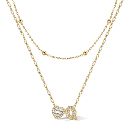 Gold cz bubble initial Q necklace with a heart-shaped pendant on a white background