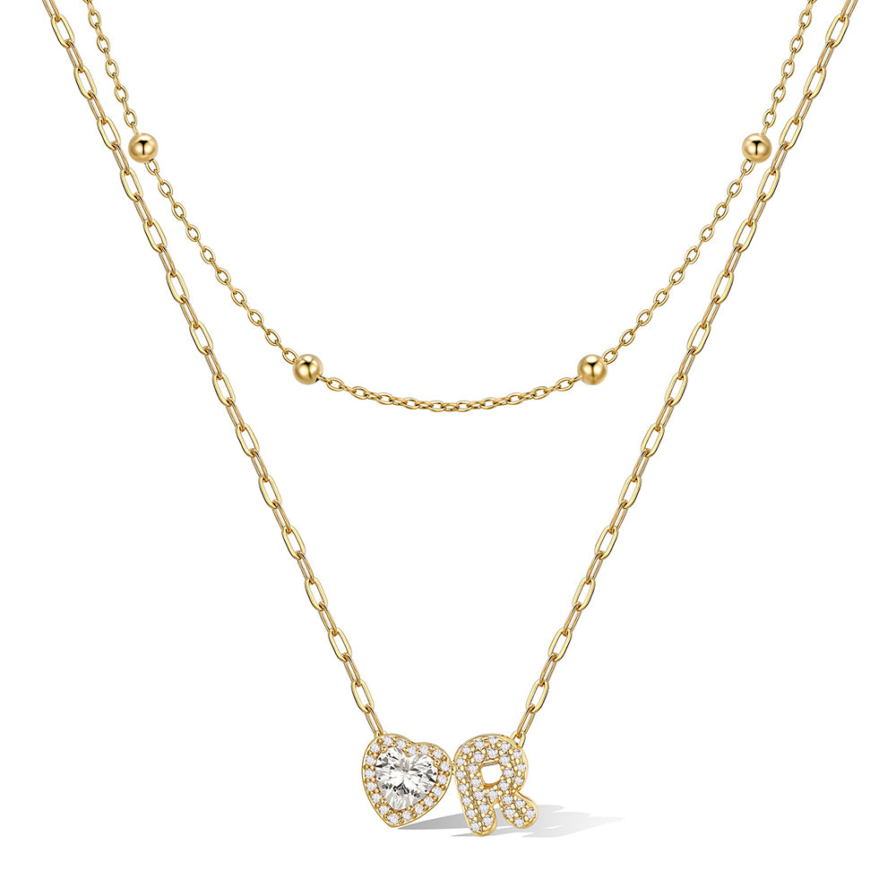 Gold cz bubble initial R necklace with a heart-shaped pendant on a white background